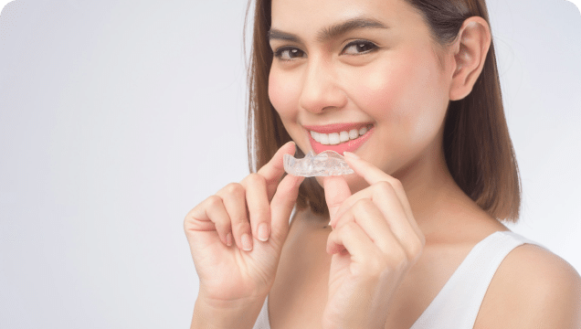 A woman playfully highlighting her invisible aligner for dental care