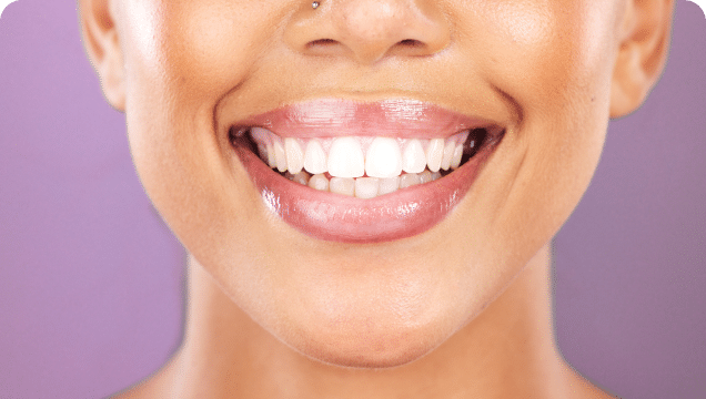 A cheerful woman displays her teeth in a wide smile, exuding happiness and confidence