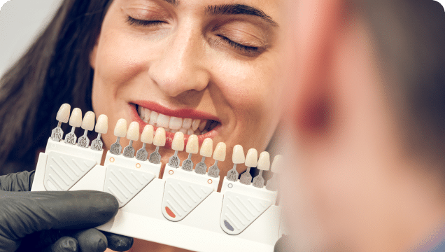 A smiling woman with a dentist fitting her teeth for an upcoming dental procedure