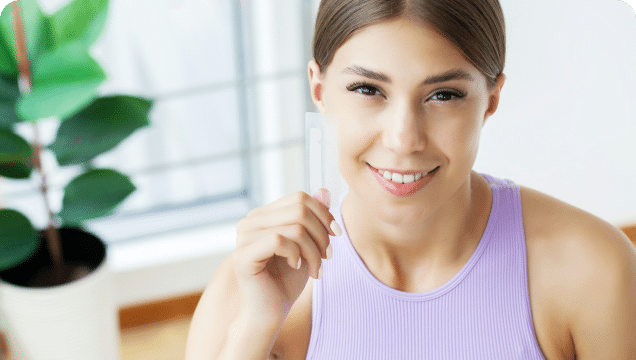 A woman in a purple shirt smiles brightly, radiating joy and positivity