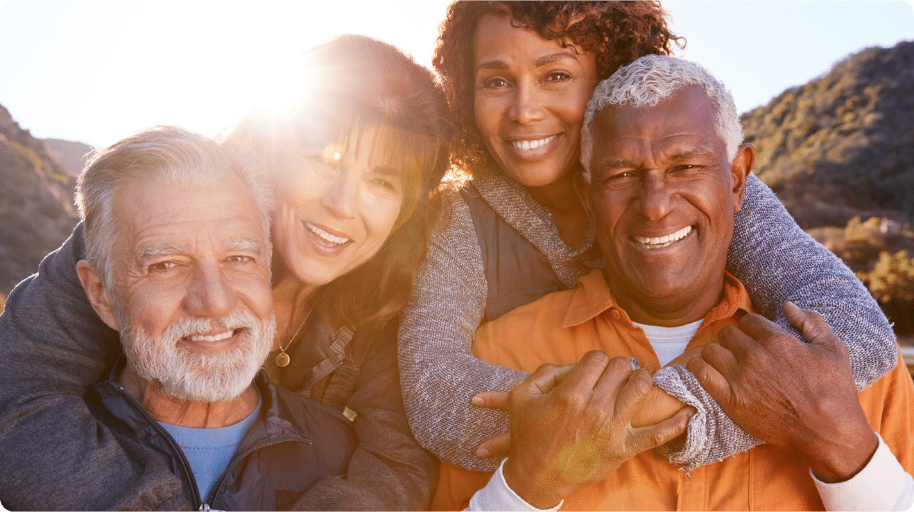 A cheerful gathering of senior friends, smiling and hugging, reflecting their strong bond and shared happiness